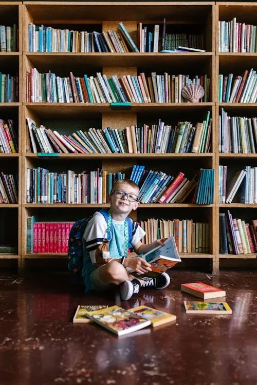 child reading a comic book on the floor on Pexels