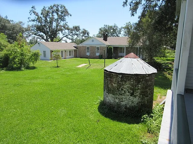Rear yard of 1811 Kid Ory Historic House - Cistern base and modern neighbor on Wikicommons