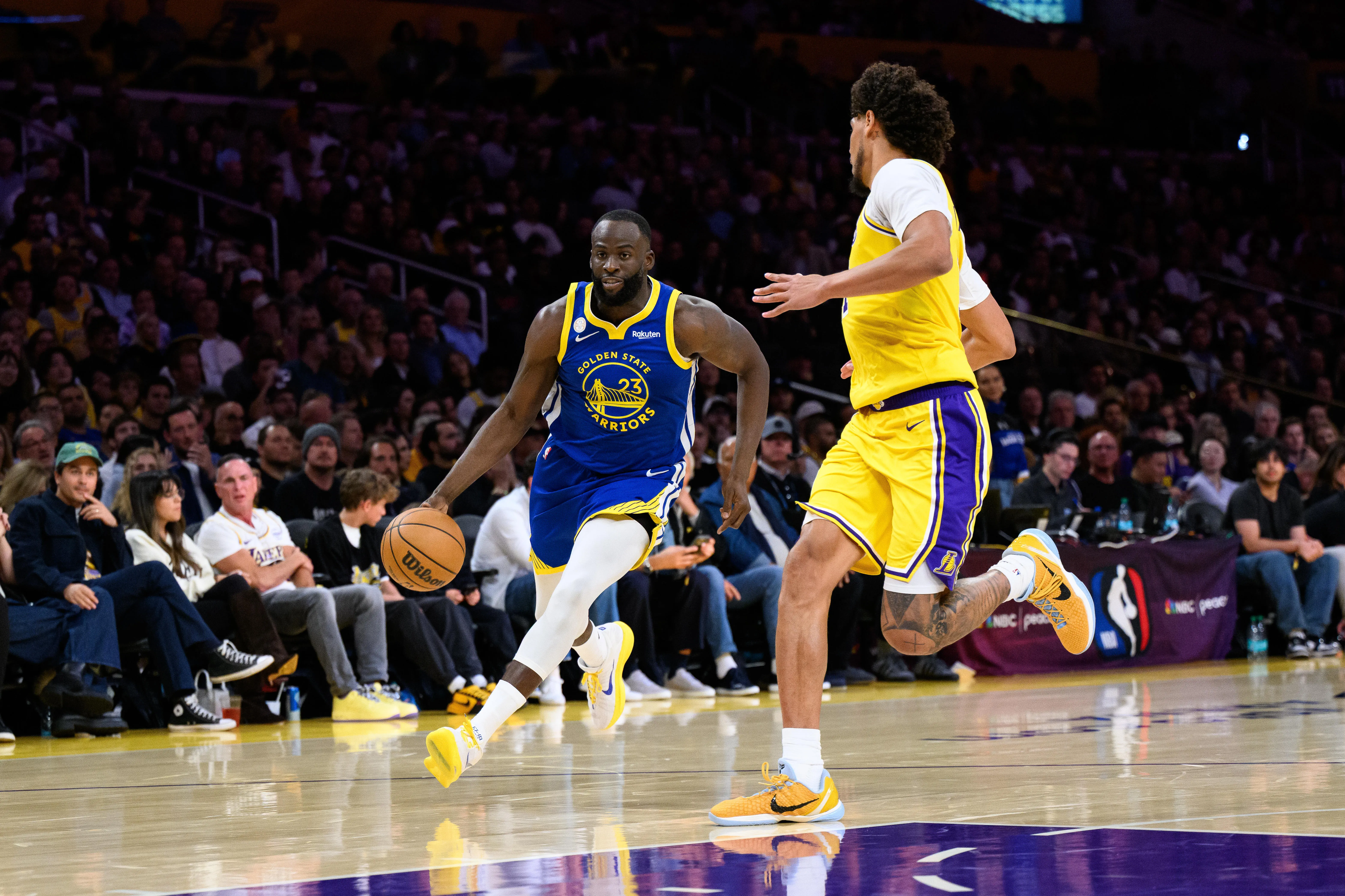 Oct 21, 2025; Los Angeles, California, USA; Golden State Warriors forward Draymond Green (23) drives against Los Angeles Lakers center Jaxson Hayes (11) during the second half at Crypto.com Arena.