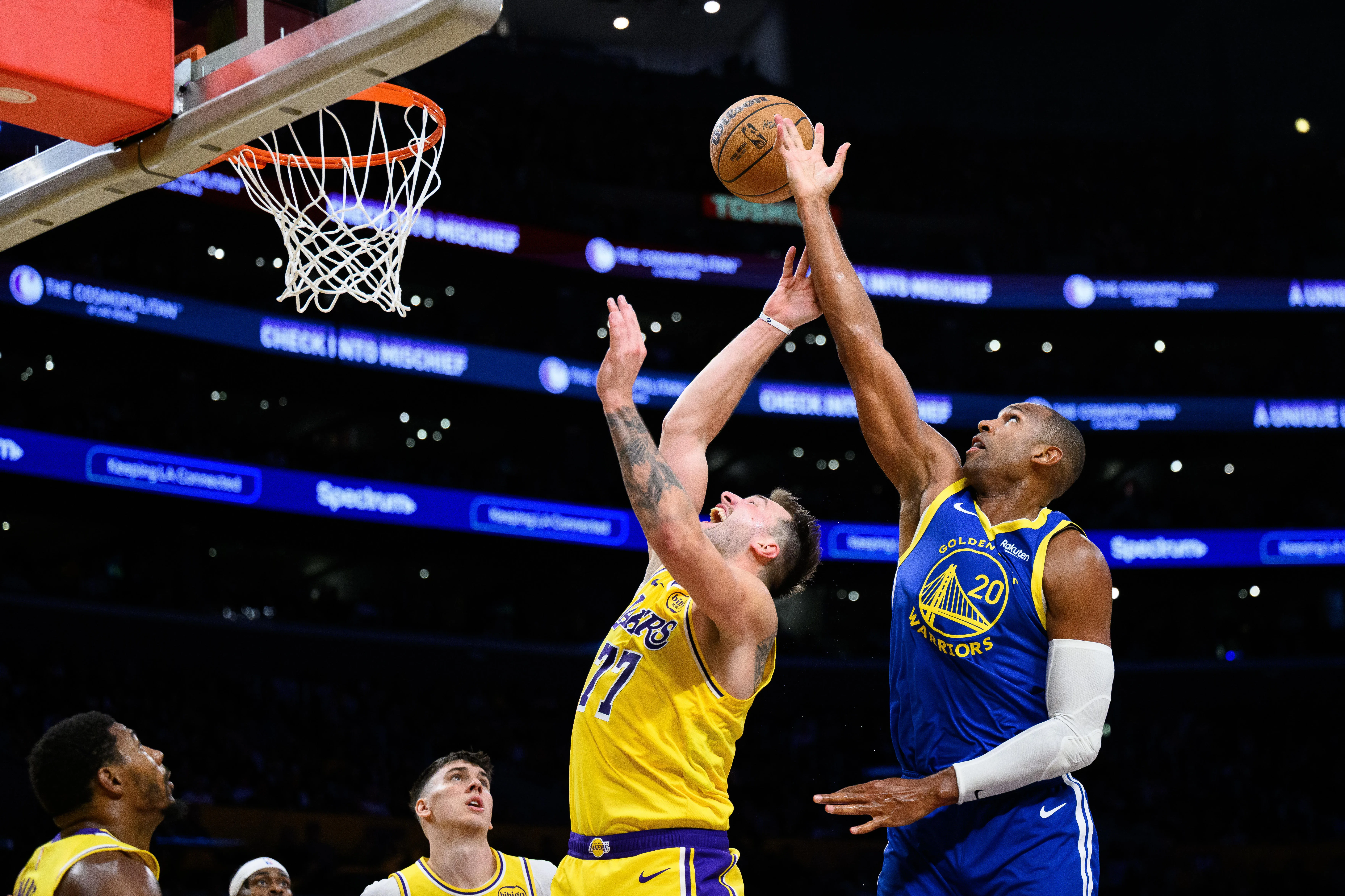 Oct 21, 2025; Los Angeles, California, USA; Golden State Warriors center Al Horford (20) and Los Angeles Lakers guard Luka Doncic (77) jump for the ball during the second half at Crypto.com Arena.