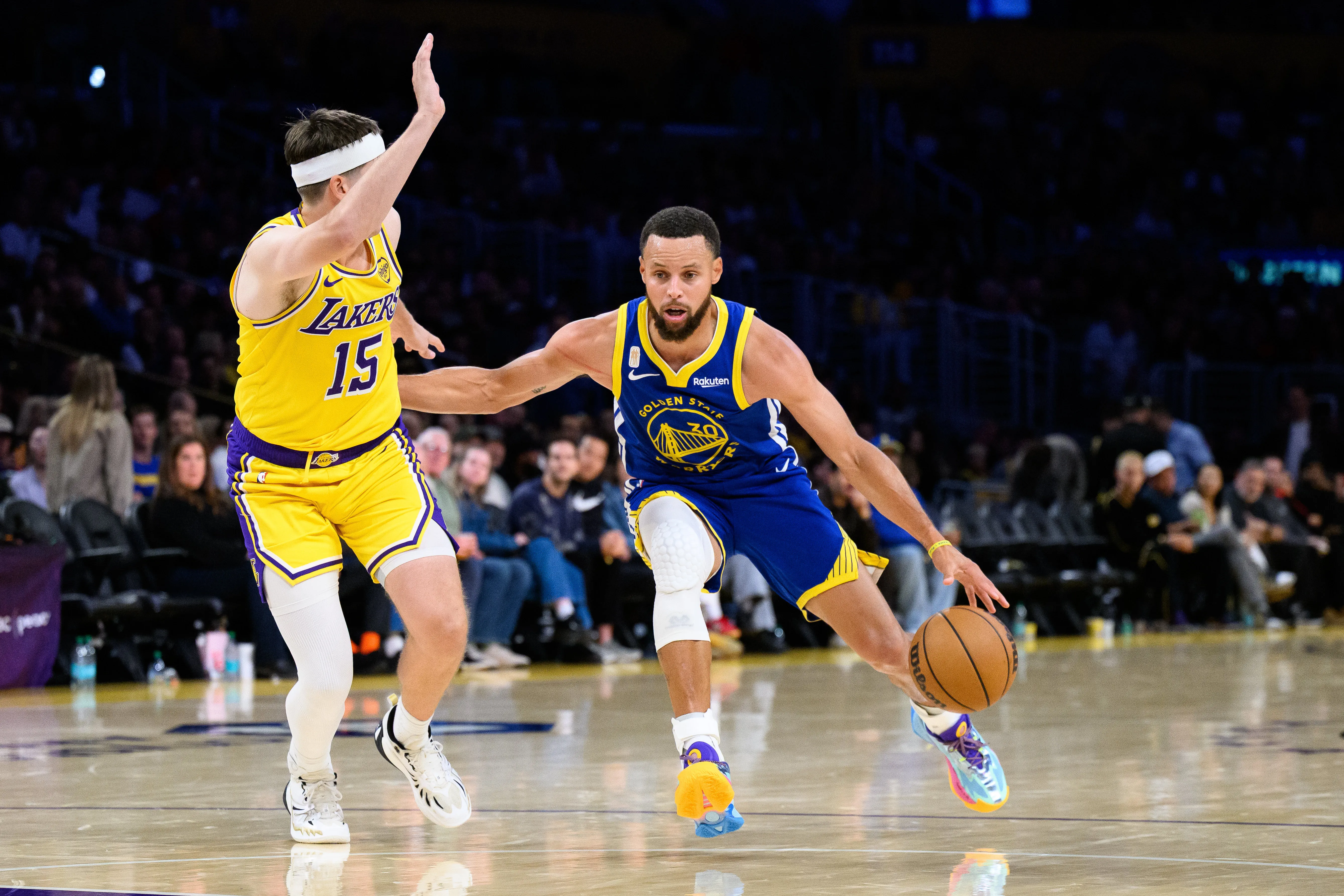 Oct 21, 2025; Los Angeles, California, USA; Golden State Warriors guard Stephen Curry (30) drives against Los Angeles Lakers guard Austin Reaves (15) during the second half at Crypto.com Arena.