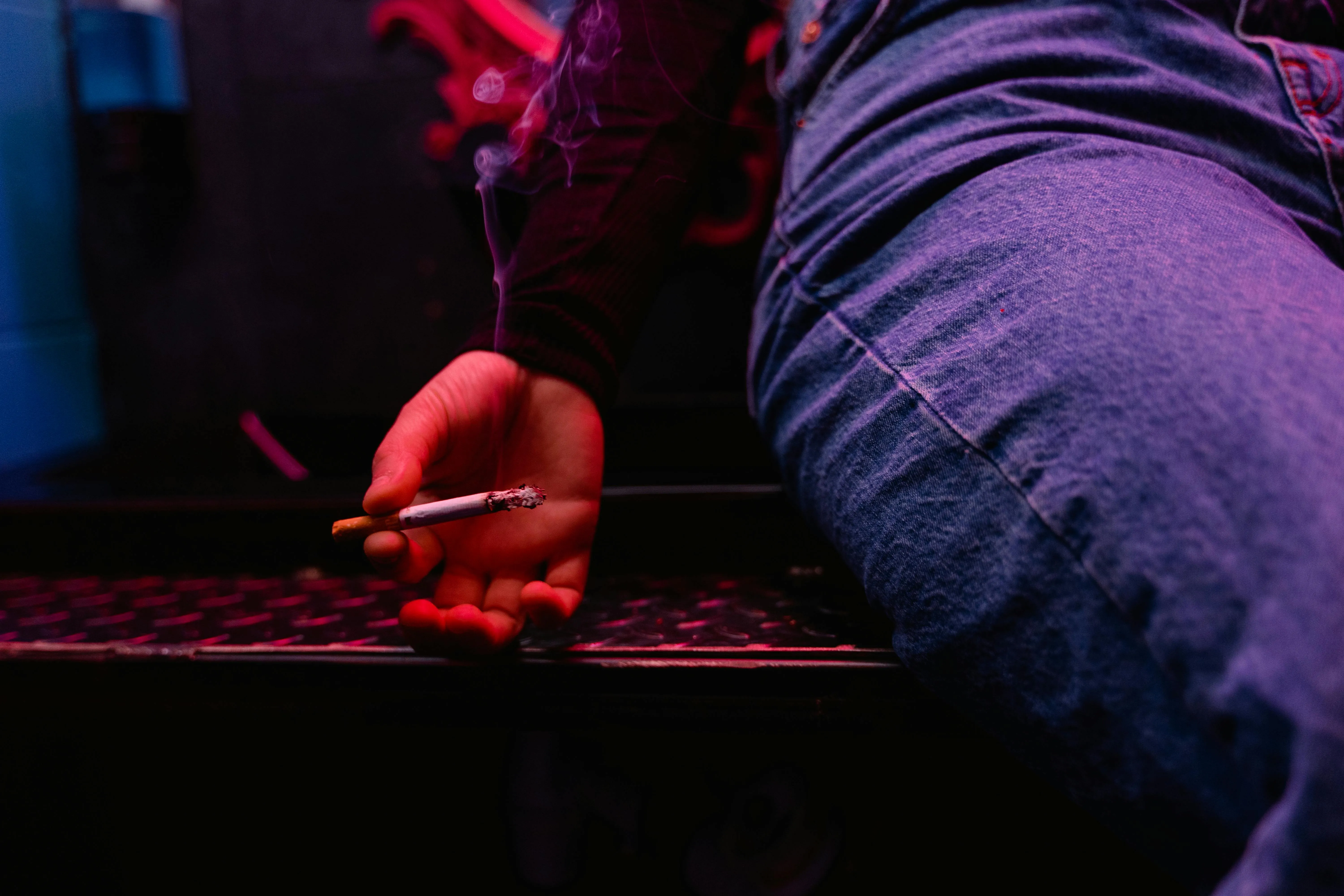 person holding a lit cigarette indoors on Pexels