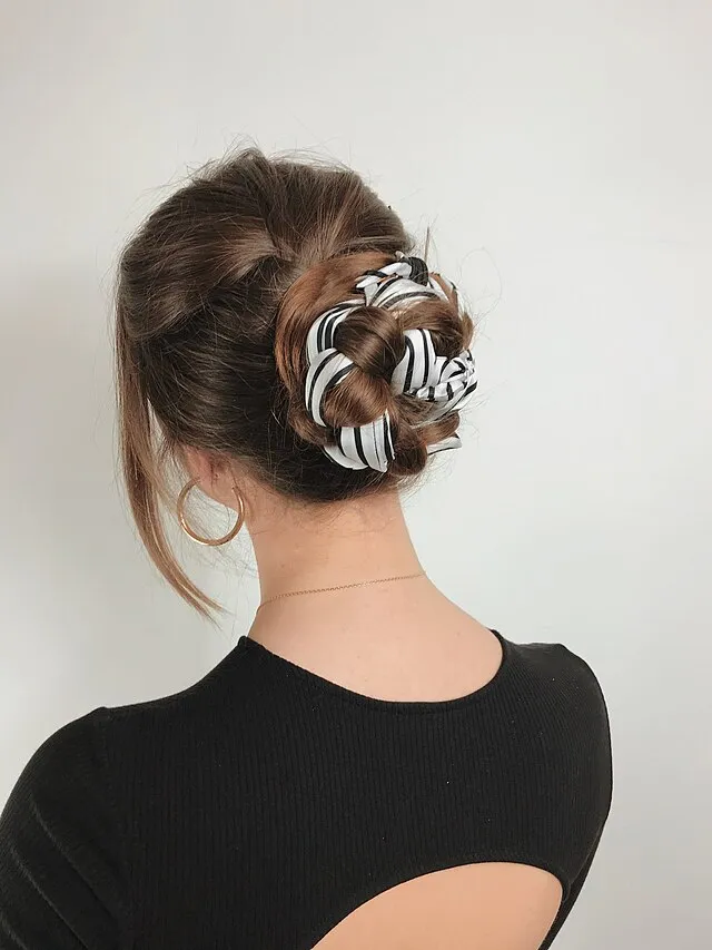 Scrunchies were the go-to accessory for tying back hair without damage. They came in every color imaginable and matched perfectly with neon outfits. Even when sweaty, they made messy buns look like part of the plan on Wikimedia Commons 